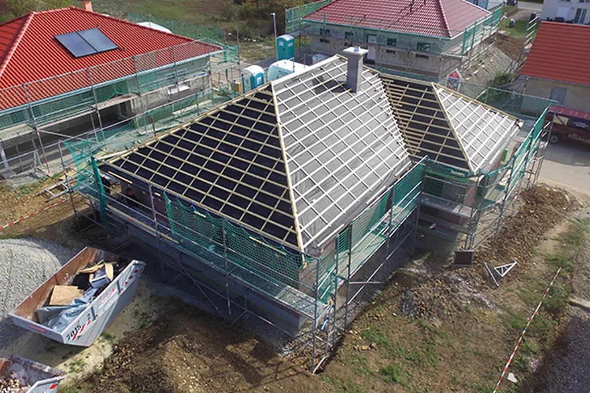 Walmdach des Bungalows mit Dachlattung und Unterdeckbahn vor der Ziegeleindeckung, eingerüstet – Luftaufnahme
