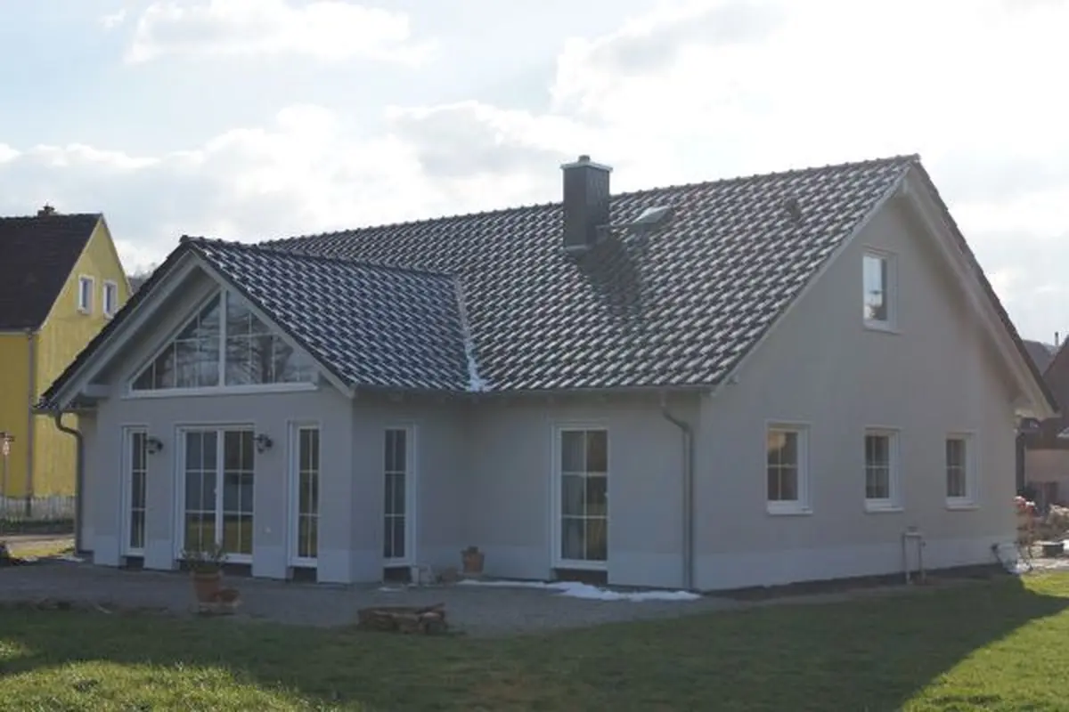 Einfamilienhaus mit grauer Fassade und Schleppgaube